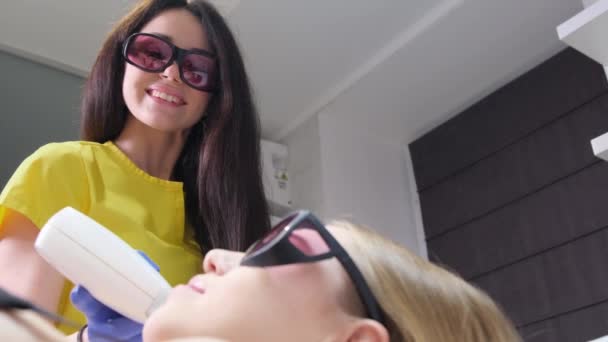 Positive Smiling Cosmetologist Protective Glasses Doing Laser Epilation Girl Beauty — Vídeo de stock