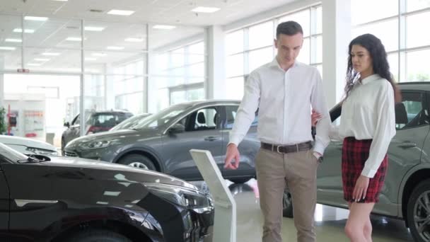 Beautiful Young Couple Inspects New Car Car Showroom Buying Car — Wideo stockowe