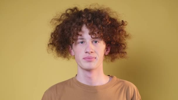 Позитивний Молодий Чоловік Красивим Кучерявим Волоссям Світло Коричневому Тлі Молодий — стокове відео