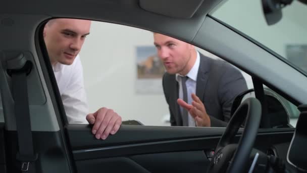 Young Man Talking Car Salesman Guy Client Buys Vehicle Showroom — Vídeo de stock