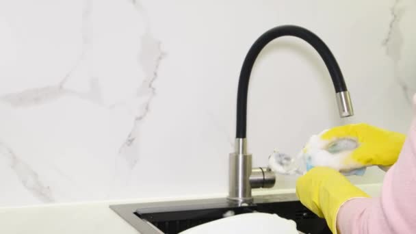 Een Vrouwenhand Wast Een Witte Plaat Met Afwasmiddel Vuile Vaat — Stockvideo