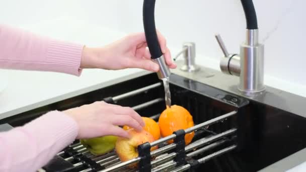 Μια Γυναίκα Πλένει Ένα Μήλο Πάνω Από Νεροχύτη Της Κουζίνας — Αρχείο Βίντεο
