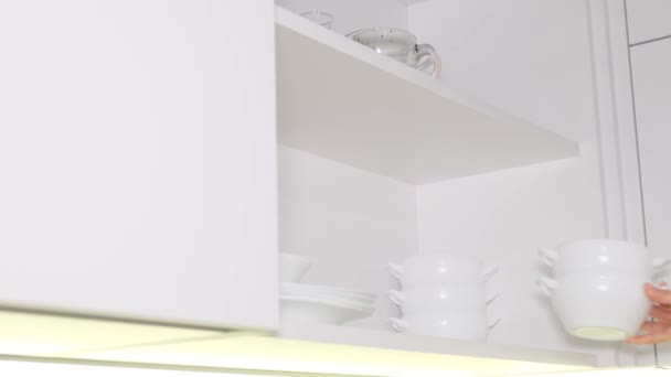 Bir Kadın Mutfaktaki Komodinin Üzerine Temiz Beyaz Tabaklar Koyar Bulaşık — Stok video