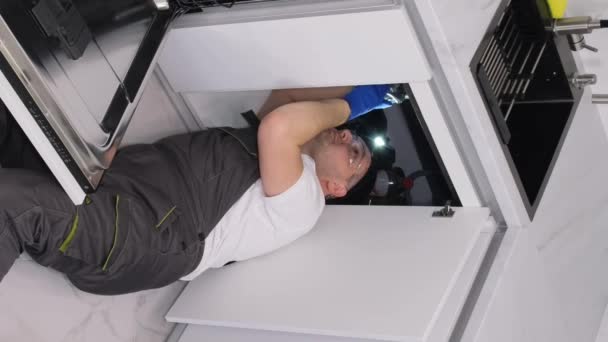 一个男管道工修理坏了的洗碗机 美国的管道服务 垂直录像 — 图库视频影像