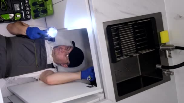 キッチンシンクの下で働く電気技師のトップビュー シンクを取り付けます バーティカルビデオ — ストック動画