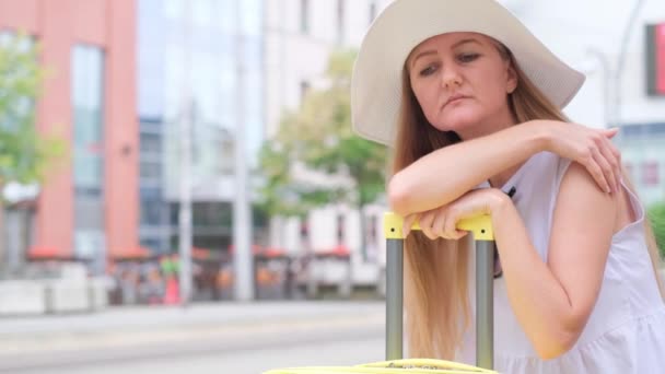 Eine Frau Sitzt Auf Einem Koffer Freien Einer Städtischen Umgebung — Stockvideo