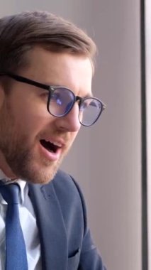 Joyful businessman in office, great news on laptop. Winner man feeling happy after receiving award celebrating financial market growth concept. Vertical video