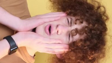 Negative emotions on the camera of a young man, a student with curly hair. The emotion of disgust, revulsion. Vertical video