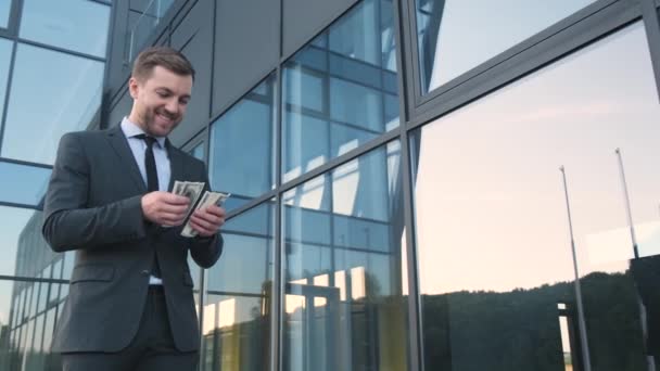 Ein Junger Erfolgreicher Geschäftsmann Zählt Dollars Vor Dem Hintergrund Eines — Stockvideo