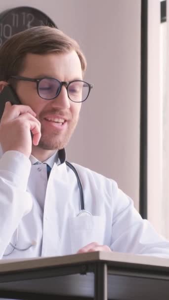 의사가 사무실에서 스마트폰을 이야기 행복한 의사는 회복된 환자와 대화를 나누고 — 비디오