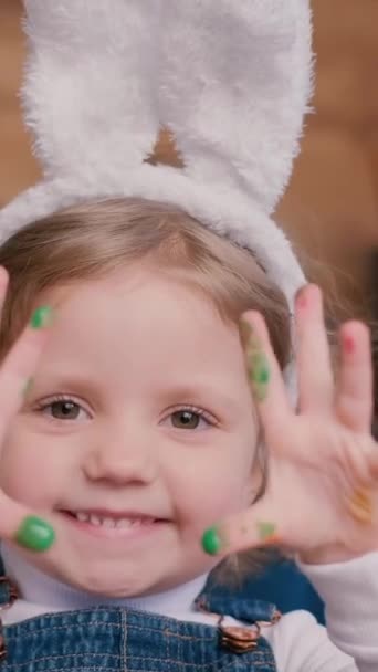 Ett Barn Med Kaninöron Leker Med Färgade Ägg Händerna Påsklovskoncept — Stockvideo