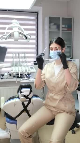 Жінка Стоматолог Сучасному Офісі Одягає Маску Окуляри Перед Лікуванням Вертикальне — стокове відео