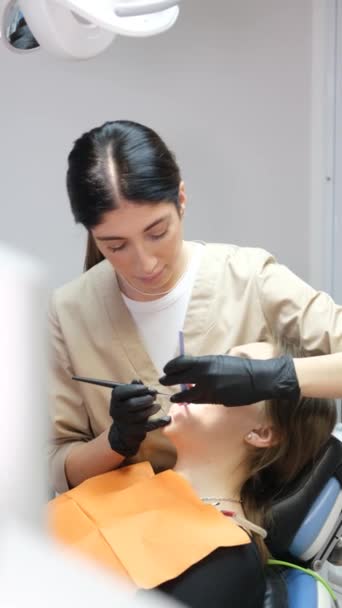 垂直录像 在现代牙科诊所治疗病人的牙齿时 健康牙齿的概念 迷人的女牙医 垂直录像 — 图库视频影像