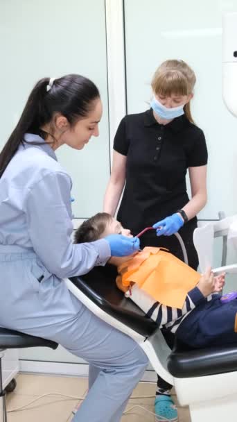 Pozytywna Uśmiechnięta Dentystka Asystentka Lecząca Małe Męskie Zęby Stomatologia Dziecięca — Wideo stockowe