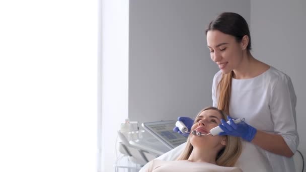 Cosmetologista Uma Massagem Facial Rejuvenescedora Uma Mulher Relaxada Usando Massageador — Vídeo de Stock
