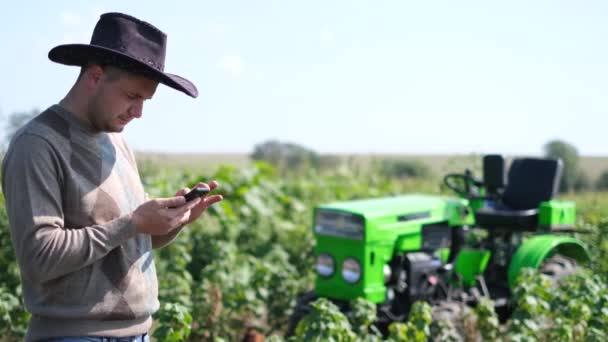Blanke Jonge Mannelijke Boer Met Hoed Het Veld Praten Mobiele — Stockvideo