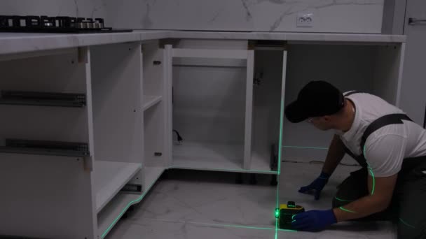 建筑工人在安装厨房家具时使用电子激光 公寓的维修 — 图库视频影像