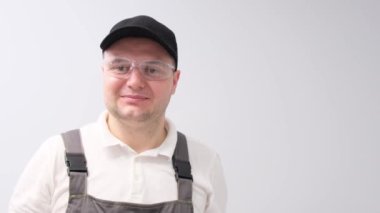 İngiliz anahtarı olan erkek bir tesisatçı portresi, gülümsüyor ve baş parmağını kaldırıyor. Tesisat hizmetleri.