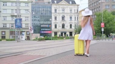 Bagajlı güzel bir kadın otele gider. Seyahat kavramı, yaz tatili. Yavaş çekim.