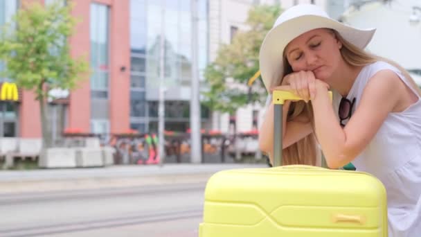 一个疲惫的女人在巴士站等公共汽车 她靠在手提箱上想睡觉 旅行和旅游概念 — 图库视频影像
