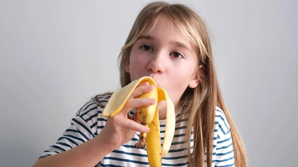 Adorable Little School Age Girl Eating Ripe Banana White Background — Stock Photo, Image