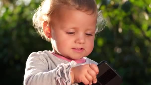 Malé Krásné Dítě Sedí Zelené Trávě Drží Smartphone Děti Venku — Stock video