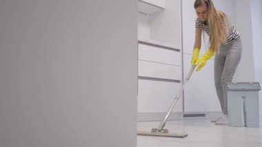 Bir kadın evi paspasla temizliyor. Ev temizliği kavramı.