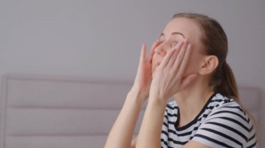 Kızın başı ağrıyor, acı çektiğini açıkça gösteriyor, başını tutuyor, kadının migreni ve depresyonu var..