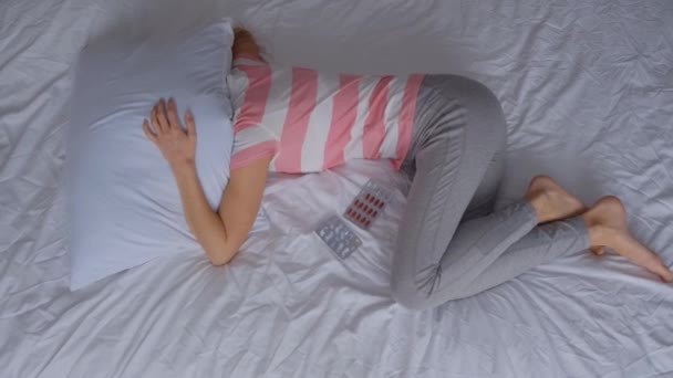 うつ病やストレスの若い女性だけが枕の下のベッドに横たわり ネガティブな感情の概念です 感情的なストレス — ストック動画