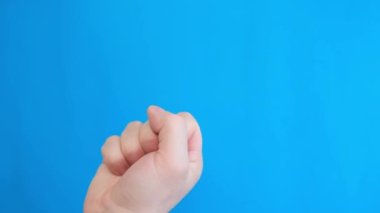 Male hand showing middle finger, insulting gesture, isolated on blue background. Fuck you concept. Rude attitude. Fuck sign