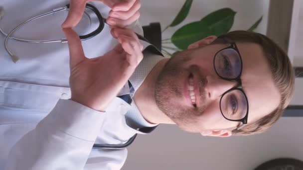 Lekarz Pokazuje Gest Serca Śmieje Się Patrząc Kamerę Koncepcja Leczenia — Wideo stockowe