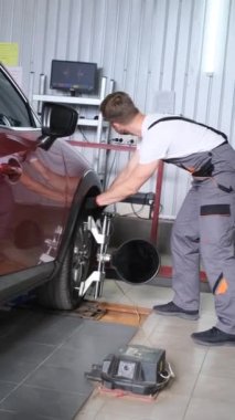 Hasar ya da aşınma var mı diye şasiyi kontrol eden bir tamircinin dikey videosu. Aracın şasesini dengeliyorum. Dikey video