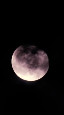 Gece bulutlu karanlık bir gökyüzünde dolunay. Astroloji konsepti. Dikey video.