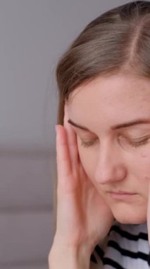 Bir kadın elleriyle şakaklarını ovuştururken baş ağrısı hisseder. Derin nefes alma ve meditasyon gibi rahatlama teknikleri. İşte yorgunluk. Dikey video