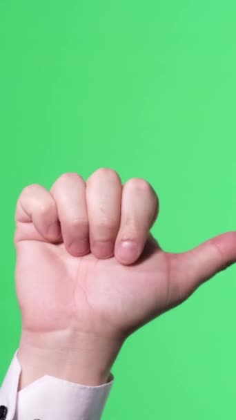 緑色の背景に男性が手を差し伸べました 親指を見せている男性の手 ジェスチャー バーティカルビデオ — ストック動画