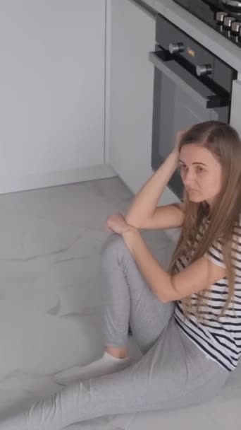 自宅の床に座っている疲れた女性 うつ病 家族の問題 パニック発作 バーティカルビデオ — ストック動画