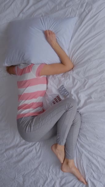 躺在床上的孤独和沮丧的孕妇蜷缩在一个球里 垂直录像 — 图库视频影像