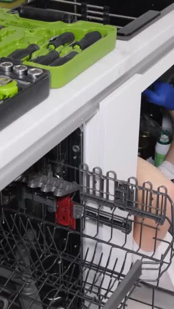 Ένας Υδραυλικός Δουλεύει Ξαπλωμένος Στο Πάτωμα Της Κουζίνας Εγκαθιστά Ένα — Αρχείο Βίντεο
