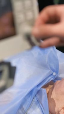 Doktor yaşlı bir kadını ameliyat eder ve damar sistemine cerrahi bir operasyon uygular. Hastane bakım konsepti. Dikey video