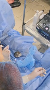 Venöz damar ameliyatının cerrahi kliniği için ameliyathanede bulunan bir phlebologist varisli damarlar için bacakları ameliyat eder. Modern, yenilikçi bir ameliyat tekniği. Dikey video