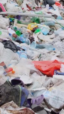 Hint Okyanusu kıyısındaki plastik çöpler. Çevre kirliliği ve çevresel felaket kavramı. Çöp dağları, doğa için felaket. Dikey video