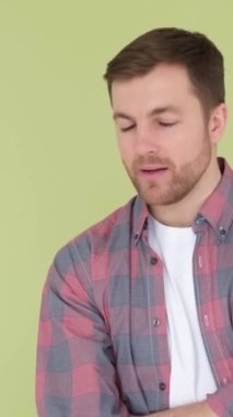 Çevreyi düşünen ve inceleyen bir adam. Stüdyoda arka planda duruyor. Adam konsantre olmuş ve düşüncelerine dalmış, derin bir düşüncelere dalmış. Dikey video