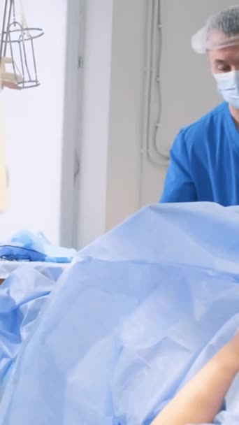医生对静脉曲张 腿部肿胀和扭曲静脉进行手术 外科医生实施静脉曲张的治疗程序 垂直录像 — 图库视频影像