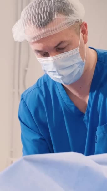 腿部手术期间静脉血管外科诊所的医生和助理 垂直录像 — 图库视频影像
