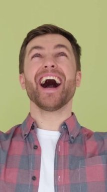 Zaferin hazzını hisseden bir adam ellerini kaldırıp yukarı bakar. Genç bir adamın mutlu ve gülümseyen yüz ifadesi. Dikey video