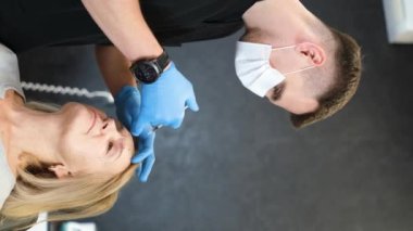 Bir doktor yaşlı bir kadının alnına yaşlanma karşıtı bir ilacı enjekte eder. Bir kozmetik uzmanı kozmetik kliniğinde iğne yapıyor. Dikey video