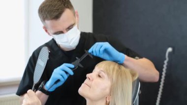 Estetik cerrahi danışmanlığından emekli bir kadın, yaş kırışıklıklarını gidermek için. Dudak büküyor, ağzın kenarlarını indiriyor. Dikey video