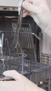 Kadın bir hemşire klinikte çalışıyor ve tıbbi aletleri sterilize ediyor. Cerrahi operasyonlar için hazırlık. Modern klinik. Dikey video