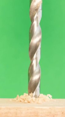 Genişletilmiş metal matkapla tahta yüzeylerde delik açılır. Fiberboard yüzeyi. İş için malzeme ve araç seçme kavramı. Dikey video