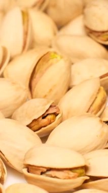 Tuzlu kavrulmuş şam fıstığı yığını yavaş çekimde bir tabağa düşer. Bira için lezzetli bir aperatif. Dikey video